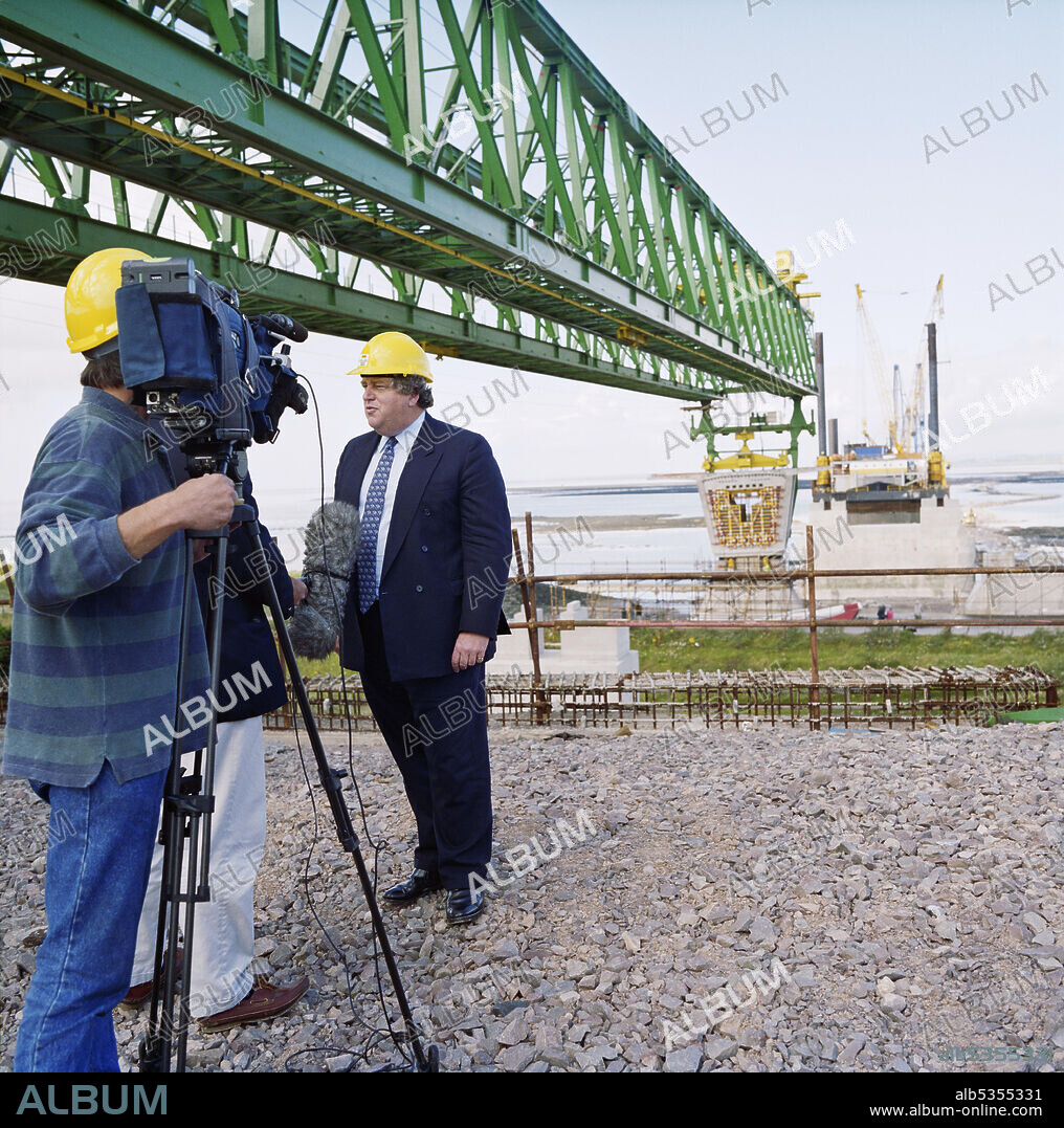 JOHN LAING PLC. Robert Key, Transport Minister, being interviewed on camera while visiting the Second Severn Crossing construction site during the installation of the first deck units of the bridge, with a specially designed launch gantry overhead. The Second Severn Crossing took four years to build and was a joint civil engineering project between Laing Civil Engineering and the French company GTM. The work started in April 1992 and the opening ceremony later took place on 5th June 1996. The crossing is a cable-stayed bridge which stretches over 5000 metres across the River Severn, 3 miles downstream from the Severn Bridge which opened in 1966.