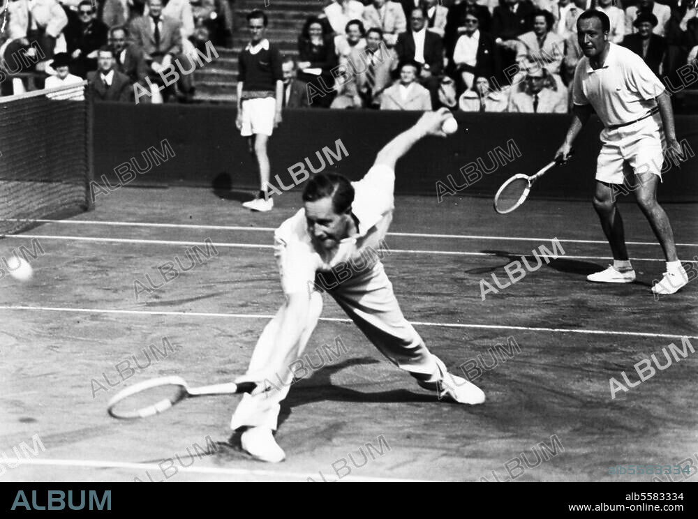 Cramm, Gottfried Freiherr von Tennisspieler Hannover 7.7.1909 - (Autounfall) bei Kairo 9.11.1976. - Wimbledon, 19. Mai 1952: Gottfried von Cramm (vorn) und Rolf Göpfert (im Hintergrund gewinnen im Doppel gegen die Dänen Kurt Nielsen und Torben Ulrich. Foto.