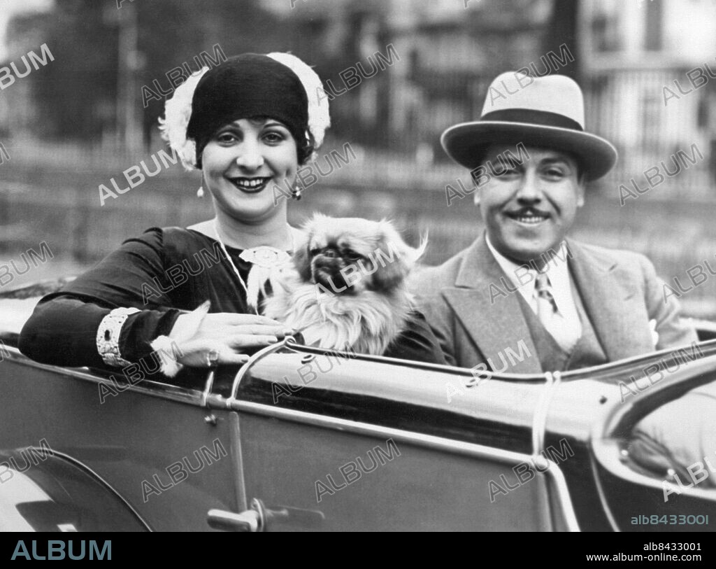 Orig. bildtext... MONTY BANKS WEDS IN SECRET. 29/9/29 It was revealed yesterday that Mr. Monty Banks, the famousfilm star, was married in New York recently to Miss Gladys Frazin, an American actress he first met in London. He was recently playing with her in Compulsory Husbands. P.P.S. A close-up of Mr. & Mrs. Monty Banks, photographed in London today. Anm. M Banks, 1897-1950, italienfödd skådespelare och filmregissör, verksam i Hollywood. G Frazin, 1901-1939, amerikansk skådespelerska. Äktenskap Äkta par Nygifta Mustascher Örhängen Armband Pekingeser Knähundar Filmstjärnor CD506 persons: MONTY BANKS;GLADYS FRAZIN sites: USA*;STORBRITANNIEN;LONDON.