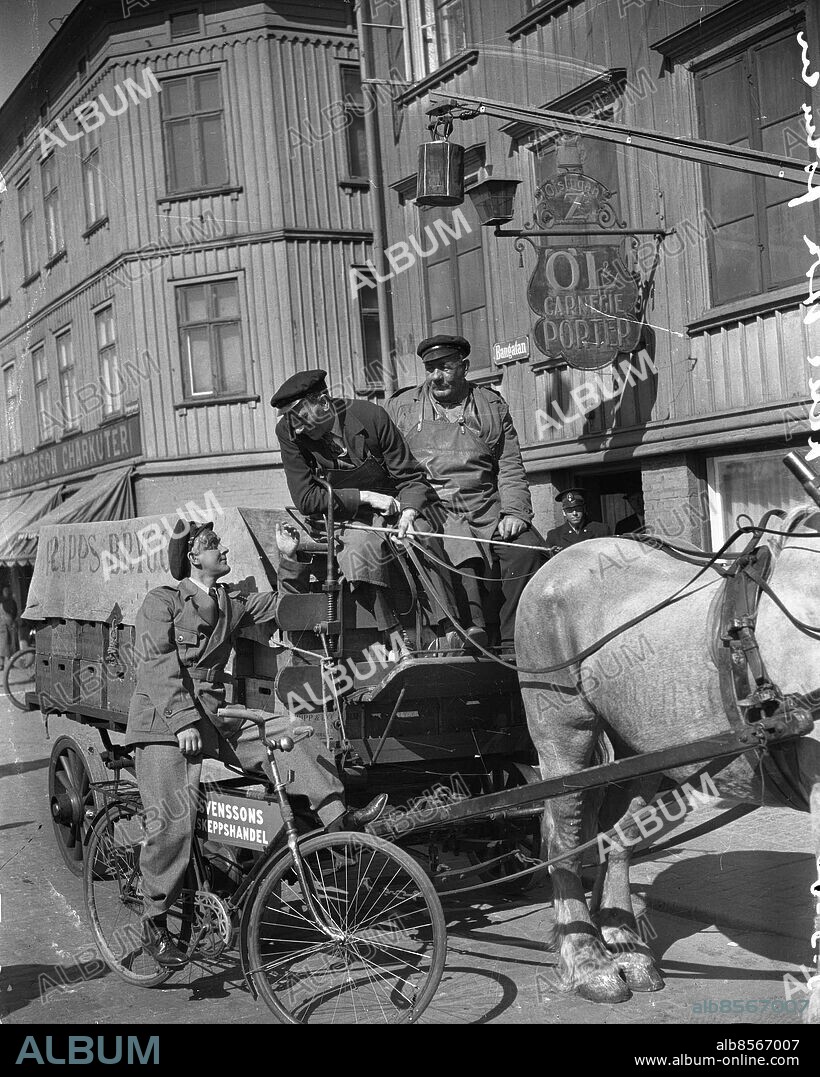 Göteborg 1940-05-03 - Filminspelning av "Vi Masthuggspojkar" - på vagnen sitter Ludde Gentzel och pratar med Åke Söderblom som spelar Kal i filmen. Här på Bangatan vid ölstugan Z - Den klassiska Ölstugan Z ägdes av Greta Hansson i 41 år och låg en gång i tiden på Bangatan vid Stigbergstorget. 1962 då huset i vilket ölstugan var belägen skulle rivas, tillvaratogs interiören av AB Pripp & Lyckholm. Även ölstugan Z flyttades från Stampen till Västra Frölunda liksom det gamla kontoret, en riktigt museal kontorsmiljö från 1800-talet. *** Local Caption *** Krep KT 04. KAMERAREPORTAGE.