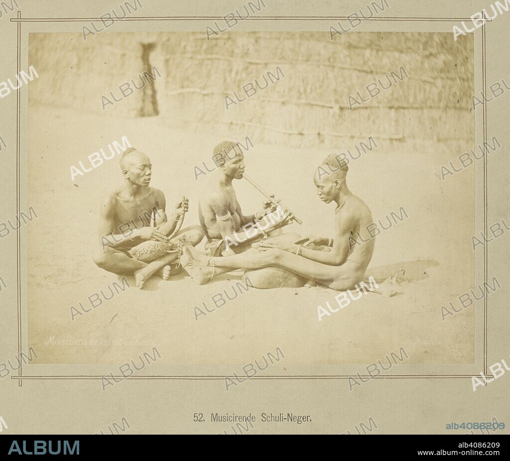 RICHARD BUCHTA. Three seated Acholi musicians playing harps and flute. The instrument to the right is a trough zither known as nanga. Die oberen Nil-LaÌˆnder. Volkstypen und Landschaften. Dargestellt in 160 Photographien. Nach der Natur aufgenommen von R. Buchta. Mit einer Einleitung von Dr. Robert Hartmann. Berlin, 1881. Source: 1789.a.13 plate 52. Language: German.