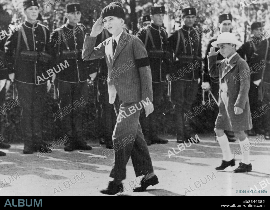 Yugoslavia Commemorates the first Anniversary of the Assassination of King Alexander. The boy King Peter II with the Queen Mother, Prince Regent, and other members of the Royal family attended the Requium service at the Oplenatz Church, Belgrade. H.M. King Peter II and his brother H.R.H. Prince Tomislav arriving at the church. They are returning the Salute of the Royal Guard. October 12, 1935. (Photo by Sport and General Press Agency Limited).