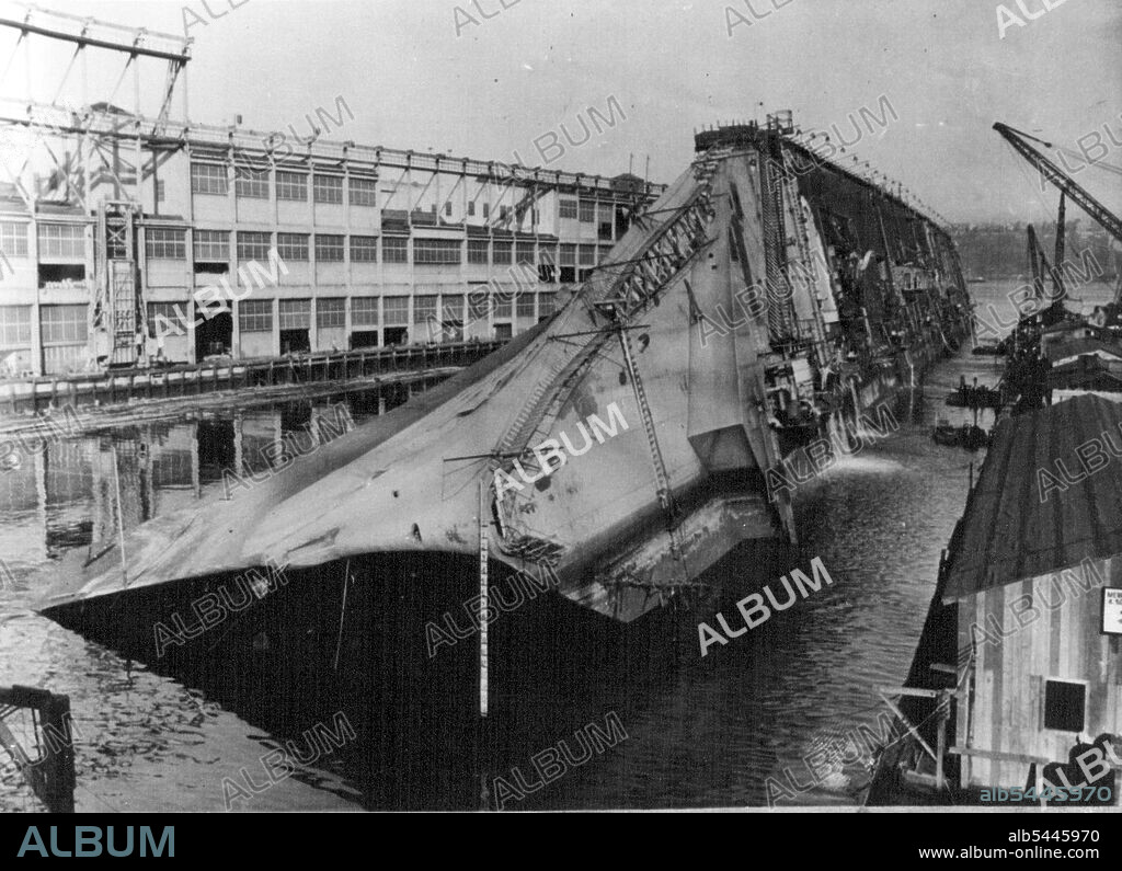 Slowly, almost imperceptible, the U.S.S. Lafayette, the former French luxury liner Normandie, August 7 began to right itself in the Hudson River Pier, New York City. Where she rolled on her side after her superstructure became top heavy with tons of water poured into her to quench a gutting fire. Waterpours from her hull august 7, as salvage operations began to right the one-time queen of the seas. September 13, 1943. (Photo by Associated Press Photo). During World War II, Normandie was seized by U.S. authorities at New York and renamed USS Lafayette. In 1942, the liner caught fire while being converted to a troopship, capsized onto her port side and came to rest on the mud of the Hudson River at Pier 88.