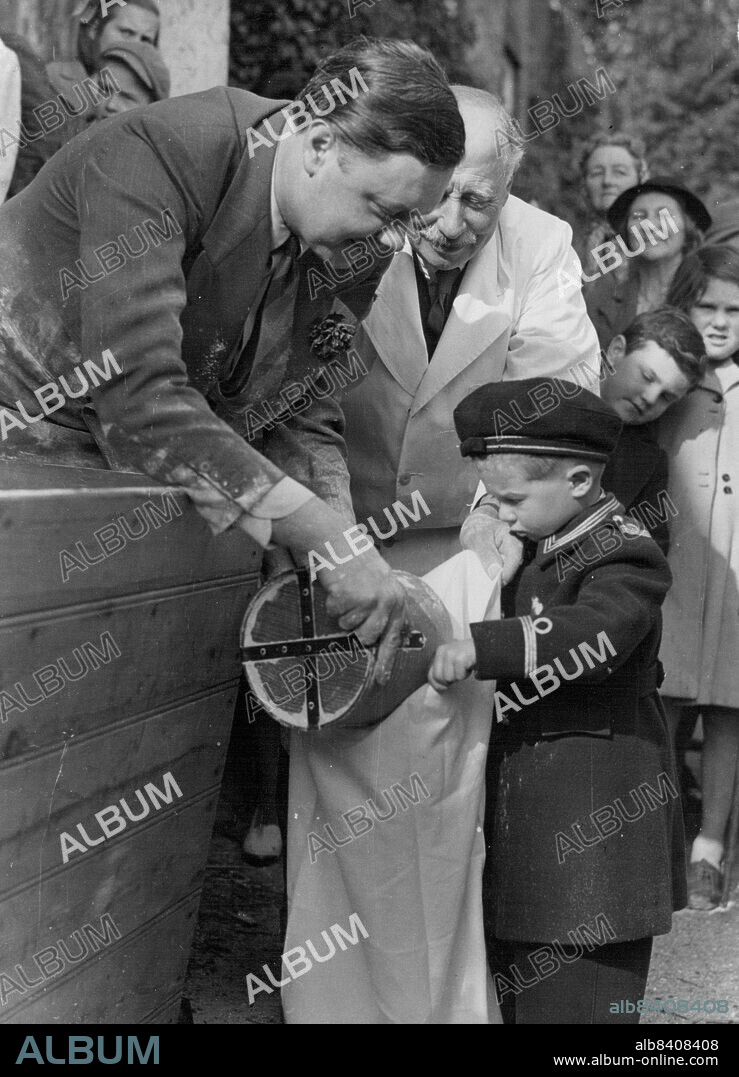 The Tichborne (Flour) Dole - Sir Anthony Doughty Tichborne, fourteenth baronet, doling out half-a-gallon of flour to young David Mills, aged three, (holding an outsize bag) during annual distribution of the legendary Tichborne Dole when 989 tenants on the estate were given flour according to the ancient custom. Each man receive one gallon of flour, the women and children half-a-gallon from a large container outside Tichborne Manor, home of the Tichborne family. March 26, 1949.