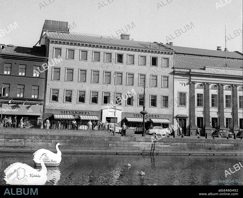 Göteborg 1957-06-17 -. Södra Hamngatan med Silvanders herrekipering, Gumperts samt Frimurarlogens restaurang - Eskilstunaboden ( järnaffären ) har reklamsvanar i kanalen. *** Local Caption *** GT. KAMERAREPORTAGE.