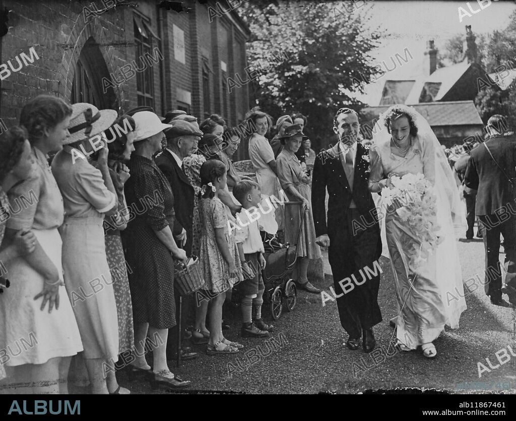 The famous Newmarket jockey, William Anthony Rickerby, took a day off from the racecourse today to Marie 24-year-old Miss Bridget Jarvis, only daughter of the late Mr WR Jarvis, who died in 1943 having trained racehorses the 3 kings of England. The families have been neighbours for years and it was Mr Jarvis he gave the jockey's first big chance. In 1933, at the age of 16 William wearing the King's colours, rode his first Newmarket winner. Picture shows: the bride and bridegroom greeted by well-wishers as cities the church this afternoon. 18 August 1947.