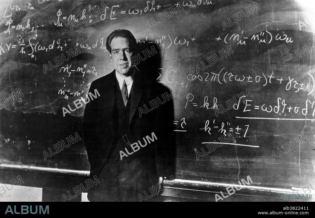 Bohr posing at blackboard, 1923. Niels Henrik David Bohr (October 7, 1885 - November 18, 1962) was a Danish physicist who made foundational contributions to understanding atomic structure and quantum mechanics, for which he received the Nobel Prize in Physics in 1922. Bohr published his model of atomic structure in 1913 wherein he introduced the theory of electrons traveling in orbits around the atom's nucleus, the chemical properties of each element being largely determined by the number of electrons in the outer orbits of its atoms. He also introduced the idea that an electron could drop from a higher-energy orbit to a lower one, in the process emitting a photon (light quantum) of discrete energy. This became a basis for quantum theory. Bohr mentored and collaborated with many of the top physicists of the century at his institute in Copenhagen. He was part of the British team of physicists working on the Manhattan Project where he was known by the name of Nicholas Baker for security reasons. His role on the project was as consultant. Following the war Bohr returned to Copenhagen where he died in 1962 of heart failure.