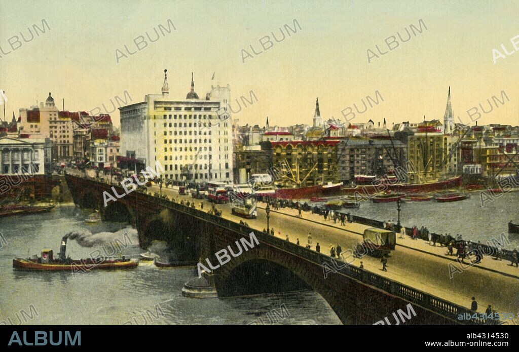 London Bridge and Adelaide House, London, 1935. Steamship on the River Thames, and traffic on London Bridge, looking towards the City from Southwark. Adelaide House, completed in 1925, was the City's tallest office block, and the first building in the City to employ the steel frame technique. Postcard.