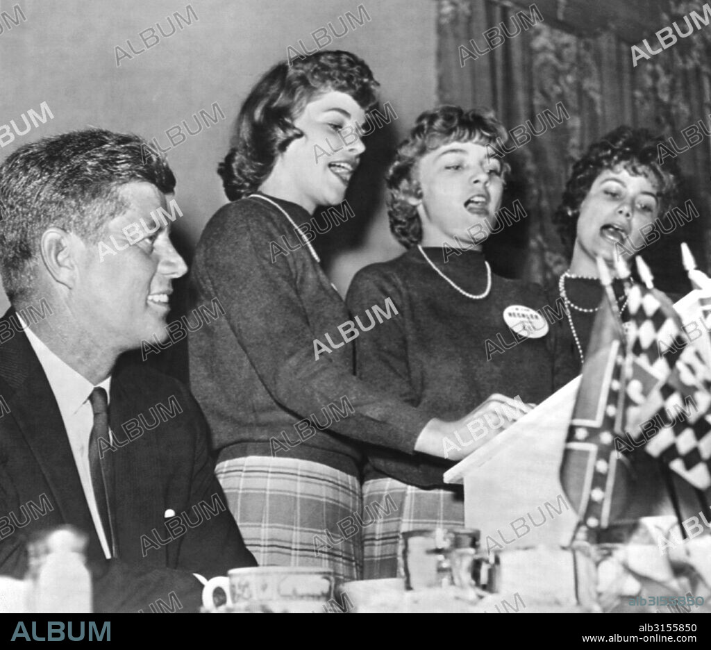 Charleston, West Virginia:  September 19, 1960 A smiling Senator John F. Kennedy listens to the Bloomfield sisters sing the West Virginia Democratic campaign song duirng his appearance in Charleston.