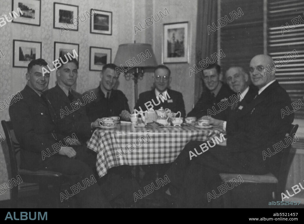 Seated Left to Right -- P/O Ryan, John -- Invercargill, P/O Williams, Alex -- Waikato, Sgt. Goodrich, Ron. -- Melbourne, Hon. Drakeford -- Melbourne, Sgt. Larkin, Colin, Harden, N.S.W., Mr. H.P. Drakeford (Hon. Drakeford's Brother), Mr. E.H. Scott-Sponsor of Anzac Center from Dunedin. January 31, 1945.