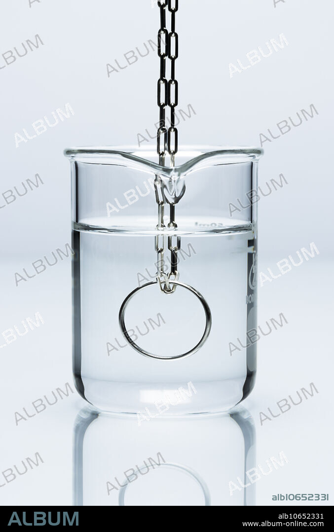 Silver in hydrochloric acid. Silver ring on a chain is immersed in hydrochloric acid (HCl). Silver (Ag) is one of the least reactive metals, it does not react with hydrochloric acid.