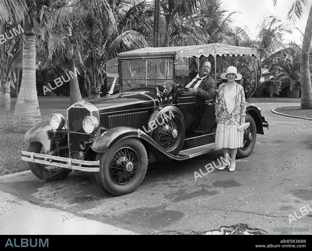 Orig. bildtext... ANNUAL VISITORS TO THE SOUTHLAND. Star Island, Fla. Col. E.H.R. Green, of South Dartmouth, Mass., and Miami Beach. Fla., son of the late Hetty Green, with Mrs. Green, and their specially-built gearless Diesel electric auto, one of the only two of its kind, both owned by Col. Green. They are shown on their estate on Star Island in Biscayne Bay, off Miami, Fla. Anm. Edward Howland Robinson Ned Green, 1868-1936, amerikansk affärsman Bil utan växel CD603 persons: EDWARD GREEN sites: FLORIDA;USA.