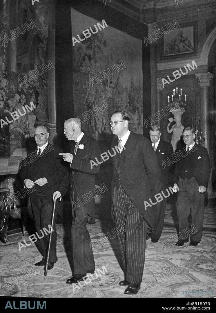 STOCKHOLM 1947-12-08. Kung Gustaf V (mitten) i samspråk med Bondeförbundets partiledare Axel Pehrsson-Bramstorp (tv) och statsminister Tage Erlander, Socialdemokraterna (th) när de anländer till statsrådslunchen i Vita havet på Stockholms slott i samband med kungajubiléet 1947-12-08. I bakgrunden fr. v. kronprins Gustaf Adolf med utrikesminister Östen Undén.. Foto: AB Text & Bilder / SVT / Kod: 5600. T&B / Gustaf V / Diverse I / K 69.