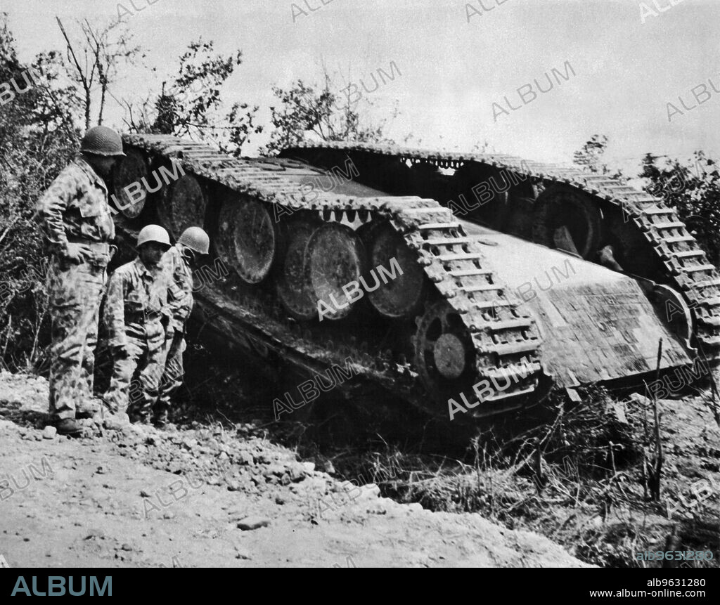 Normandy, France, 1944 American soldiers dressed in new type camouflage uniforms looking at German Tiger Tank.