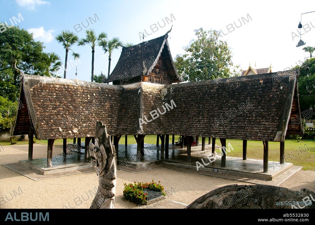Wat Ton Kwen (??? ??? ?????), more formally known as Wat Inthrawat (??? ?????????), means ‘Temple of Sugar Palms’ in kham muang or Northern Thai, and sure enough the rustic temple, set in a small village amid verdant rice paddies, is surrounded by tall and elegant sugar palms. Built at the start of the reign of Chao Kawilorot (1856-70) in 1856, Wat Ton Kwen is among the finest and purest examples surviving of traditional 19th century wooden Lan Na temple architecture. No doubt because of its small size and relative isolation, it has been spared the ‘improvements’ and other indignities suffered not just by most of its contemporary structures, but also by much older Lan Na religious buildings. The most distinctive features at Wat Ton Kwen are the typically Lan Na viharn or gabled assembly hall, and an unusual cruciform, four-porch mondop or open-sided pavilion.