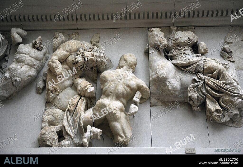 Pergamon Altar. Built by order of Eumenes II Soter. 164-156 BC by artists of the school of Pergamon. Marble and limestone. South frieze. Gigantomachy. An unidentified goddess is followed by Hephaistos, who raises a two-headed hammer aloft. He is followed by another unidentified kneeling god who thrusts a spear into the body. Next, the goddess Eos rides sidesaddle into battle. She pulls back her horse and is armed with a torch. Pergamon Museum. Berlin. Germany.