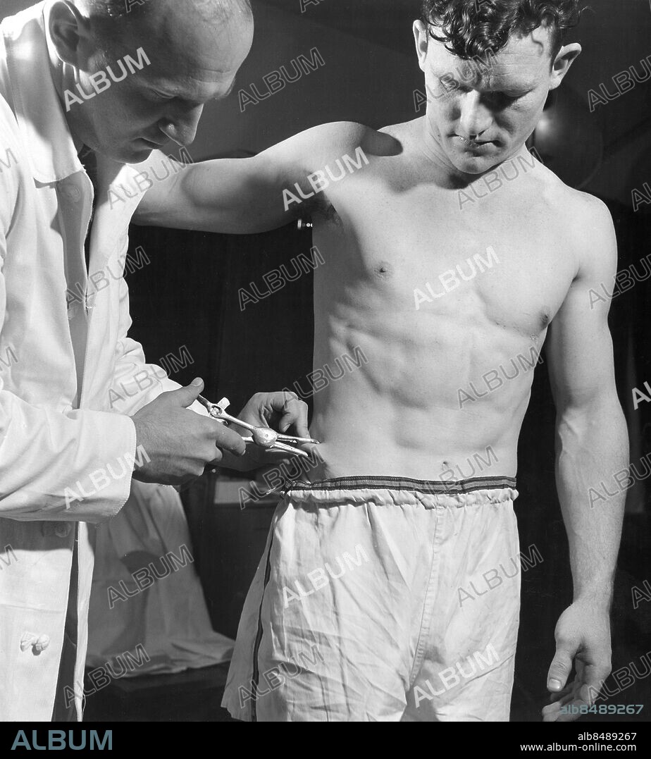 USA 1948.. Bob Richards, amerikansk stavhoppare, får sina fettceller undersökta.. Foto: International News Photos / AB Text & Bilder / SVT / Kod: 5600. Engelsk originalbildtext.. Mapp: Sportkuriosa Tester m.m 3566. Fat pad Bar överkropp.