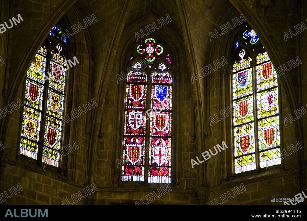 Stained glass windows in the Chapel of Santa Agata, Barcelona, Spain, 2007. The Chapel of Santa Agata is a beautiful 14th century church, composed of a single Gothic aisle with main arches supporting a polychrome wood coffered ceiling. The high altar contains a masterpiece of Catalan art by Jaume Huguet (1464) featuring themes from the Adoration of the Magi and the Crucifixion,  known as the Constable Retablo. At the end, under a large arch, is the semicircular stairway leading to the Royal Palace. The former sacristy has a large iron mechanical clock dating from the year 1576. The old windows in the choir and gallery show the various coats-of-arms of the counts of Barcelona.