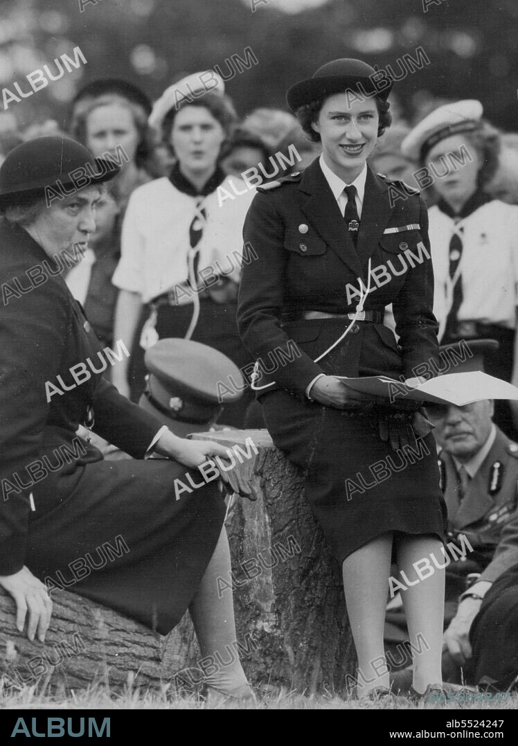 Princess Margaret Round The Camp Fire -- Princess Margaret, wearing the uniform of Sea Ranger Commodore, joins in the camp fire singing at a Girl Guide rally at Hyland's Park near here. Earlier she took the salute at a march past of the 6000 girls at the rally.At left is Lady Baden Powell, the chief Guide. June 26, 1949. (Photo by Pictorial Department).