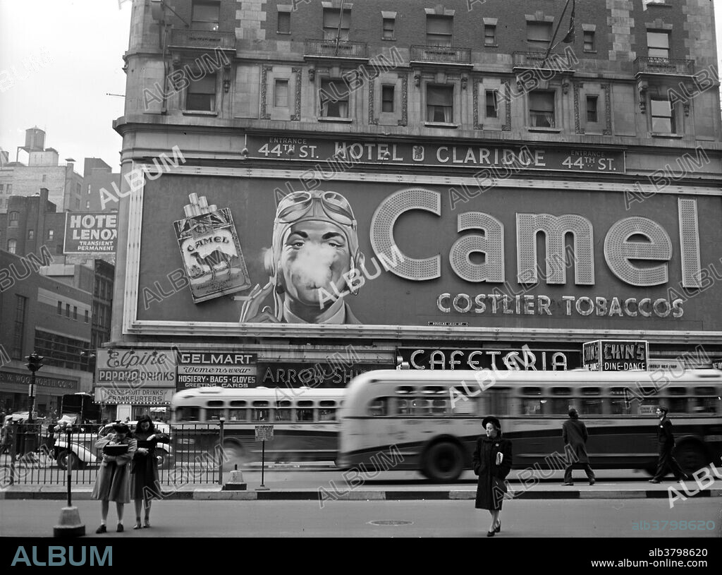 Camel cigarette advertisement at Times Square, NYC. In 1941 a billboard was installed that marked one of the most well known advertising campaigns in history; Camel cigarettes. This billboard was apart of Times Square's history for 26 long years. The billboard displayed a man blowing smoke toward his audience with "Camel" gleaming in bright lights. The billboard blew the illusion of a giant smoke ring every four seconds. Steam from a piston-driven diaphragm was forced out of a hole, and this mimicked a person smoking. Photographed by John Vachon, 1943.