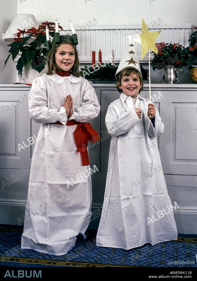 STOCKHOLM 1984-12-12. Kronprinssessan Victoria som Lucia med tända ljus på huvudet och prins Carl Philip som stjärngosse med strut på huvudet och stjärna i handen i samband med julfotograferingen av den svenska kungafamiljen på Drottningholms slott i december 1984.. Foto: Anders Holmström / TT / Kod: 50100.