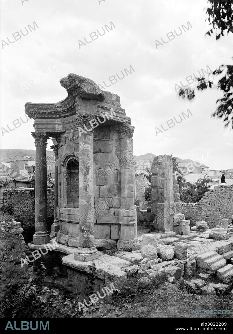 The Temple of Venus was added under Septimius Severus in the early 3rd century but destroyed under Constantine, who raised a basilica in its place. It lies about 150 yards rom the southeast corner of the Temple of Bacchus. It was known in the 19th century as El Barbara or Barbarat el-Atikah (St Barbara's), having been used as a Greek Orthodox church into the 18th century. Baalbek is a town in the Beqaa Valley of Lebanon situated east of the Litani River. After Alexander the Great conquered the Near East in 334 BC, the existing settlement was named Heliopolis. The city retained its religious function during Greco-Roman times, when the sanctuary of the Heliopolitan Jupiter-Baal was a pilgrimage site, and one of the largest sanctuaries in the empire. Starting in the last quarter of the 1st century BC (reign of Augustus) and over a period of two centuries (reign of Philip the Arab), the Romans had built a temple complex in Baalbek consisting of three temples: Jupiter, Bacchus and Venus. On a nearby hill, they built a fourth temple dedicated to Mercury. Photographed by the American Colony (Jerusalem) Photo Department, 1936.