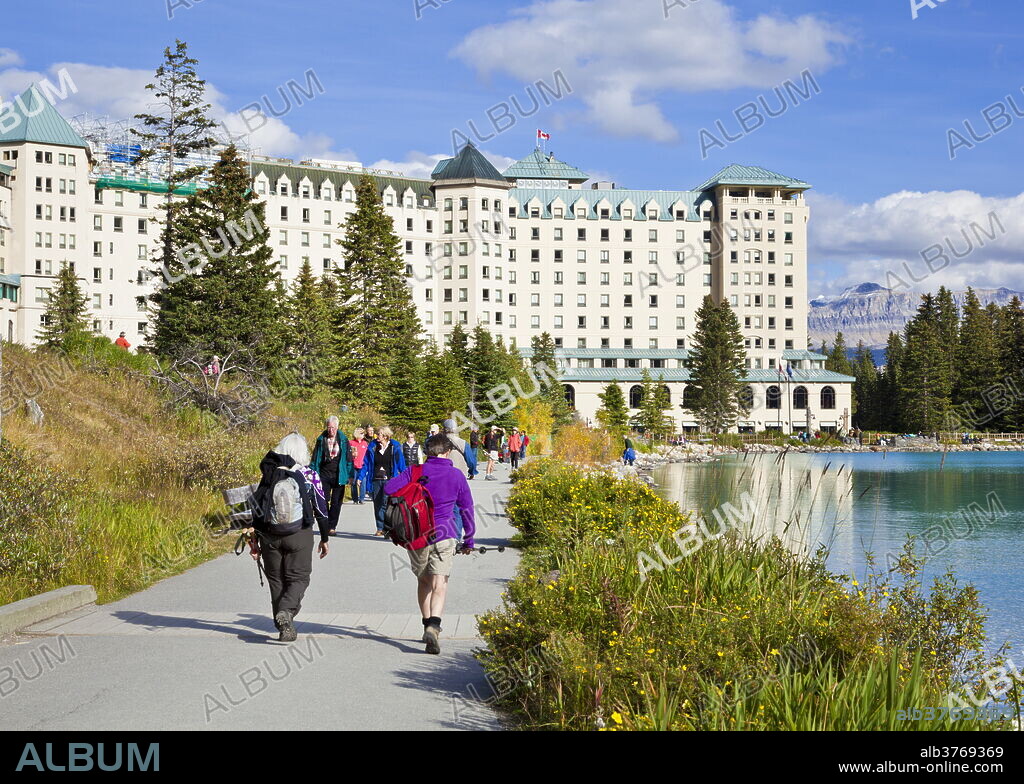 Hikers walking towards The Fairmont Chateau Lake Louise Hotel, Lake Louise, Banff National Park, UNESCO World Heritage Site, Alberta, The Rockies, Canada, North America.