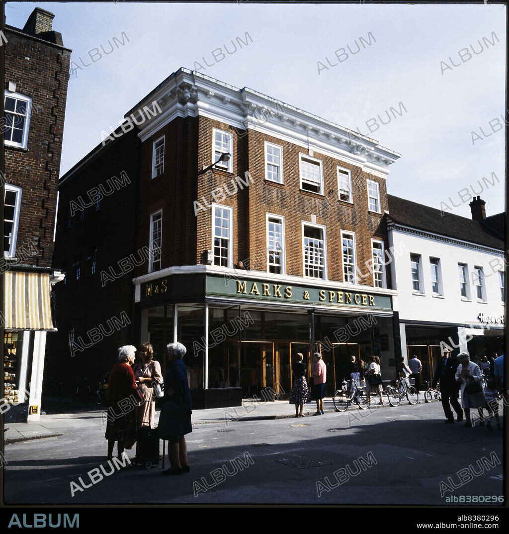 NICHOLAS ANTHONY JOHN PHILPOT. Marks and Spencer, 16-18 East Street, Chichester, West Sussex, 1970s-1990s. The Marks and Spencer store at 16-18 East Street, seen from the south-west with a group of shoppers talking in the foreground. The store opened in November 1935. It later became an M&S Foodhall.