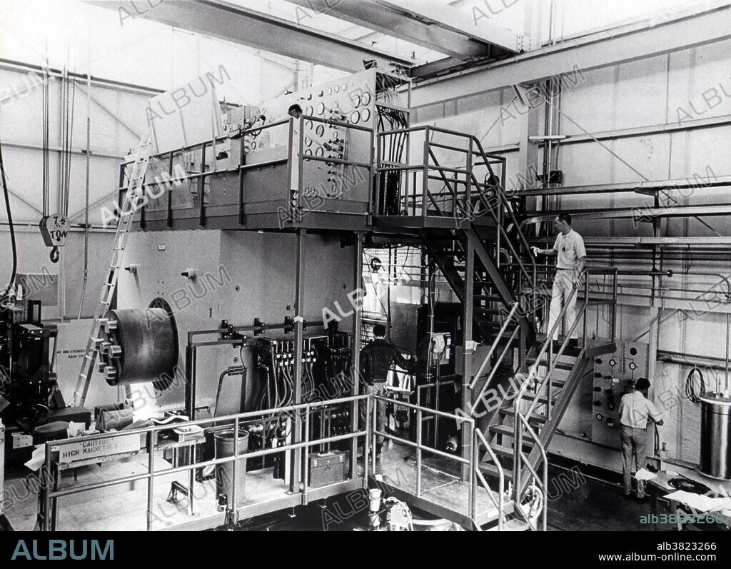 40 inch liquid hydrogen bubble chamber at the Stanford Linear Accelerator, 1968. A bubble chamber is a vessel filled with a superheated transparent liquid (most often liquid hydrogen) used to detect electrically charged particles moving through it. The bubble chamber is similar to a cloud chamber, both in application and in basic principle. It is normally made by filling a large cylinder with a liquid heated to just below its boiling point. As particles enter the chamber, a piston suddenly decreases its pressure, and the liquid enters into a superheated, metastable phase. Charged particles create an ionization track, around which the liquid vaporizes, forming microscopic bubbles. Bubble density around a track is proportional to a particle's energy loss. Bubbles grow in size as the chamber expands, until they are large enough to be seen or photographed. SLAC National Accelerator Laboratory, originally named Stanford Linear Accelerator Center, is a U.S. Department of Energy National Laboratory operated by Stanford University under the programmatic direction of the U.S. Department of Energy Office of Science and located in Menlo Park, California. The SLAC research program centers on experimental and theoretical research in elementary particle physics using electron beams and a broad program of research in atomic and solid-state physics, chemistry, biology, and medicine using synchrotron radiation.