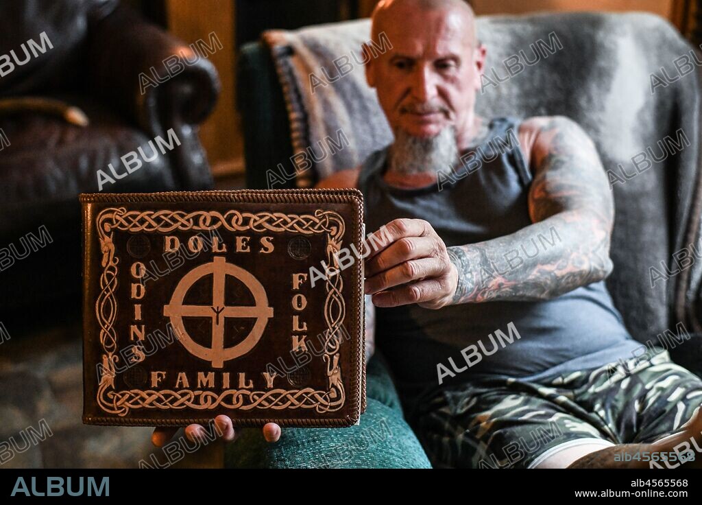 CHESTER DOLES. September 17, 2019, Dahlonega, Georgia, US: CHESTER J. DOLES, 59, sits in his living room, and displays a book he treasures, 'The Holy Book of the Aryan Tribes' by Ron McVan, which is wrapped in a leather cover Doles carved with the title, 'Doles Family Odins Folk.' (Credit Image: © Miguel Juarez Lugo/ZUMA Wire). 17/09/2019