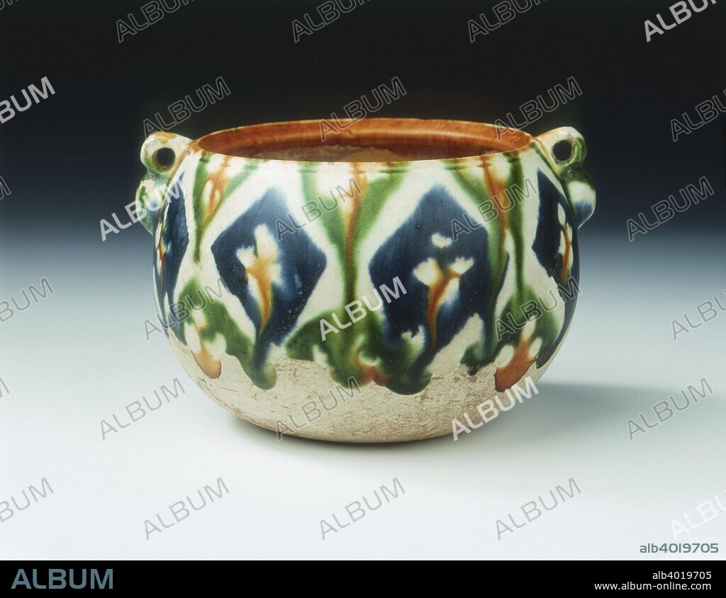 Sancai pottery jar with floral and geometric patterns, Tang dynasty, China, early 8th century. An earthenware jar with wide mouth, globular body and a pair of loop handles in the shape of double gourds. The upper part of the exterior is decorated with stylised wax-resist floral and geometric patterns in brown, blue and green lead glazes on a white ground over a white slip. The interior is covered with a buff glaze.