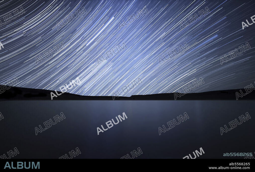 The celestial equator is at the same distance from both celestial poles which is why the stars seem to travel in a straight line during a long exposure. In this 120 minutes exposure the south celestial pole is towards the top left of the image while the north celestial pole is below the horizon towards the bottom right.