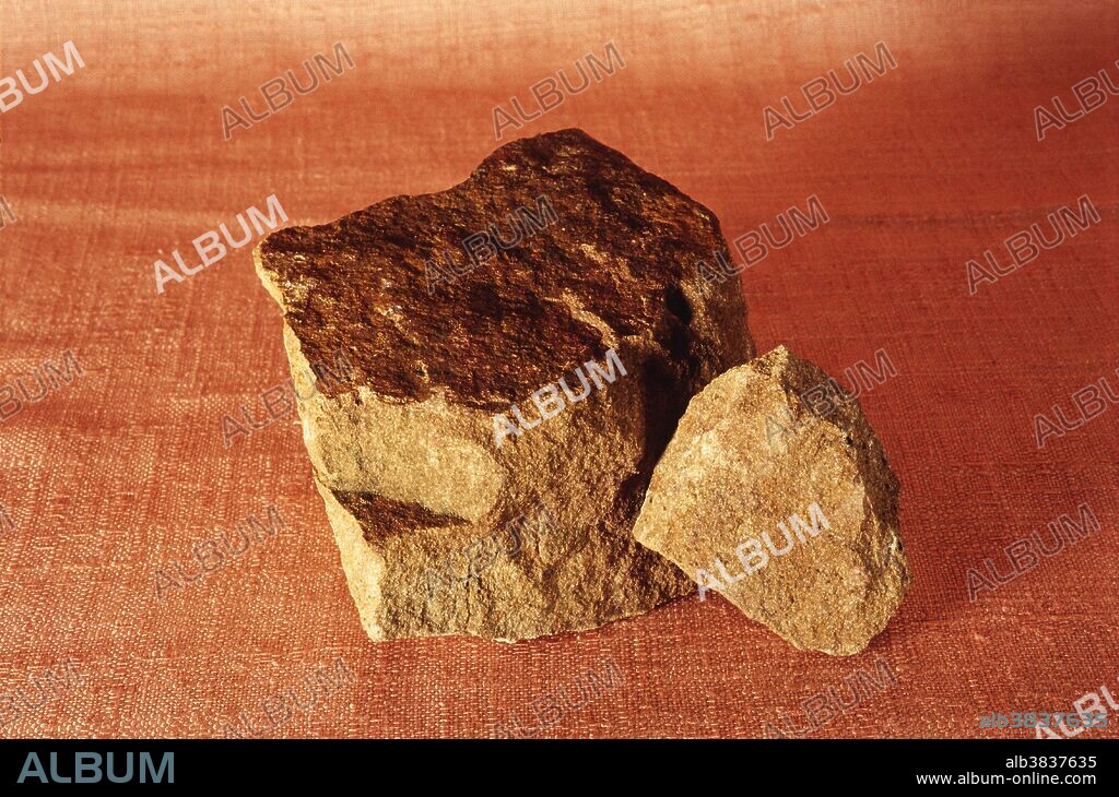 Sandstone, a sedimentary rock containing quartz grains, feldspar, mica and iron oxide.