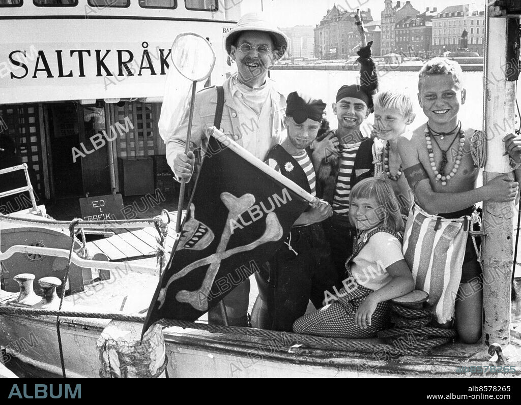 Stockholm 1964-08-14. Barnens dag. Församlade kring Tjorven (Maria Johansson) är från vänster Sven Robinson Kruse Hernström, Christer Hellqvist, Benny Sellén, Gösta Warodell och Per Schönnebring.. Salta vindar blåser kring årets Barnens Dag-firande i Stockholm. I Humlegården skall Tjorven och alla de andra Saltkråkorna vara värdar och i Vasaparken bygger man upp en Robinson Crusoe-miljö med hyddor och flotte och hela härligheten.. Foto: Ronny Karlsson / DN / TT / Kod: 151. ** SvD OUT **.