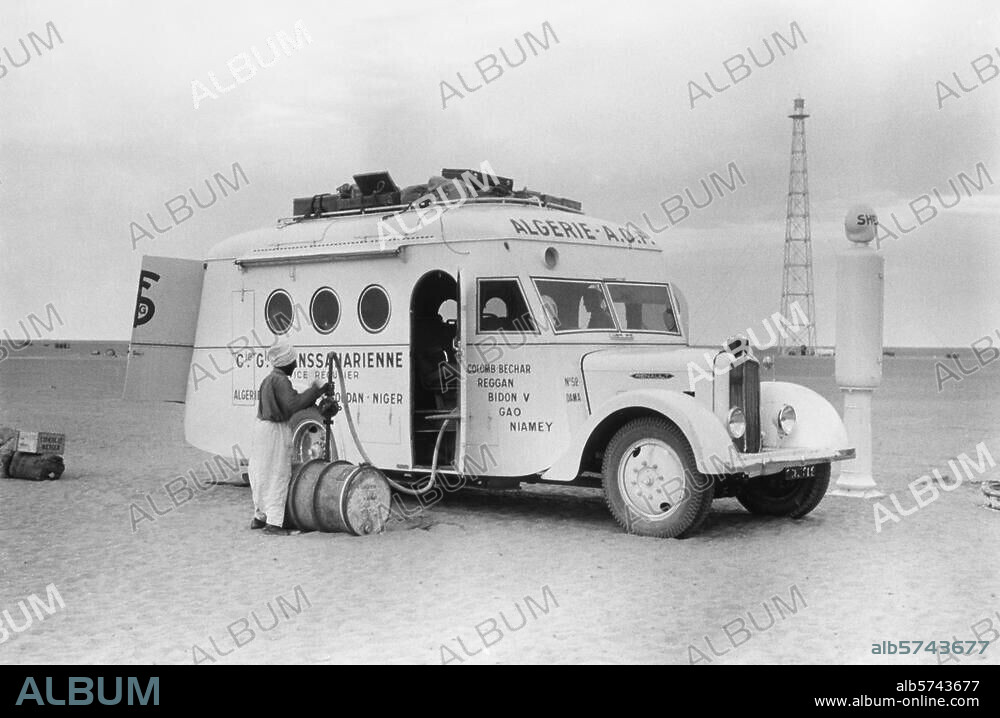 Verkehr:. Autobus. Ein Autobus der algerischen Compagnie Générale Transsaharienne wird am Bidon Cinq (Post Maurice Cortier) in der Sahara betankt (im Hintergrund ein Leuchtturm für den Flugverkehr). Foto, 1936 (aus einer Serie: "La Route Transsaharienne").