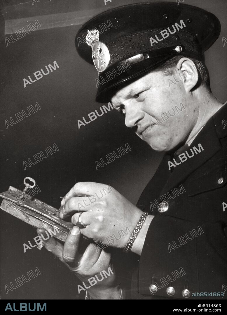 ARKIV - 1951 Fjärdingsman Tore Hedin, undersöker ett dörrlås vid utredningen av ett av sina egna mord i Hurva och Tjörnarp. Hedin mördade genom mordbrand sina föräldrar och flera åldringar på ett ålderdomshem samt ett yxmord på kvarnägare Allan Nilsson. Hedin tog senare sitt liv genom att dränka sig i Bosarpsjön. Denna bild sändes ut över Europa via telefoto och radierades till USA och intresset var stort i media världen världen. Foto: TT Kod: 190 . COPYRIGHT SCANPIX SWEDEN.
