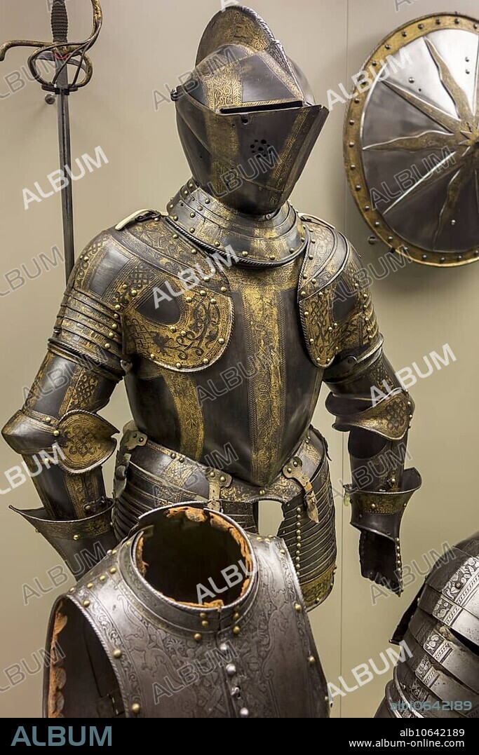 16th century browned and gilded medieval suit of armour with armet, burgonet helmet, burgundian sallet at the Royal Museum of the Army and of Military History in Brussels, Belgium