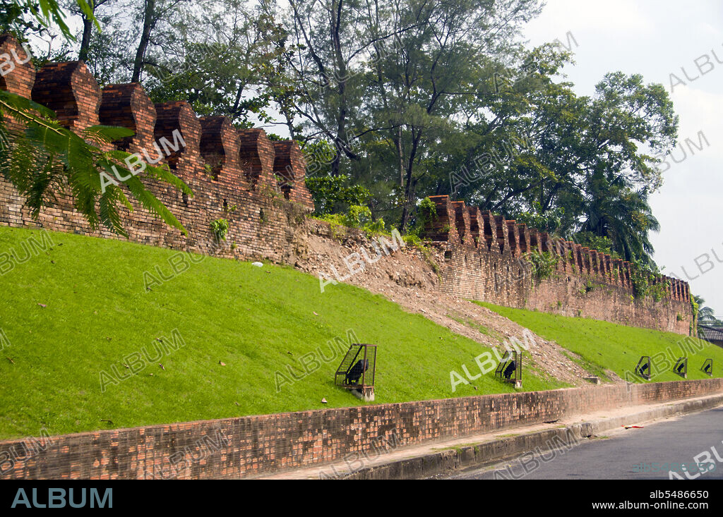 Just a part of one of the shorter sides of Nakhon Si Thammarat's long, original rectangle of walls is still standing, but this section has been carefully restored. These impressive remains still gives a clear impression of what the fortifications must have been like when they stood within defensive moats, resisting first King Taksin, and then the invading Burmese, during the early Rattanakosin period. The remains of the ancient brick-built walls of Nakhon Si Thammarat are topped with crenellated battlements in the familiar shape of Buddhist bai sema. The imposing structure is broken by part of the only surviving city gate, the northern one, which boasts a strongly fortified gate house and a wide, high arch. In times past the walls of Nakhon Si Thammarat were defended by four strong corner-forts, but these have totally disappeared. Originally the wall enclosed an area measuring about half a kilometre from East to West, by just over two kilometres from North to South. Today only the north gate, Pratu Chai Neua or Pratu Chai Sak, still survives at least, in part. The former south gate has completely disappeared and is today only remembered in the nearby road named Thanon Pratu Chai Tai, or 'South Gate Road'.