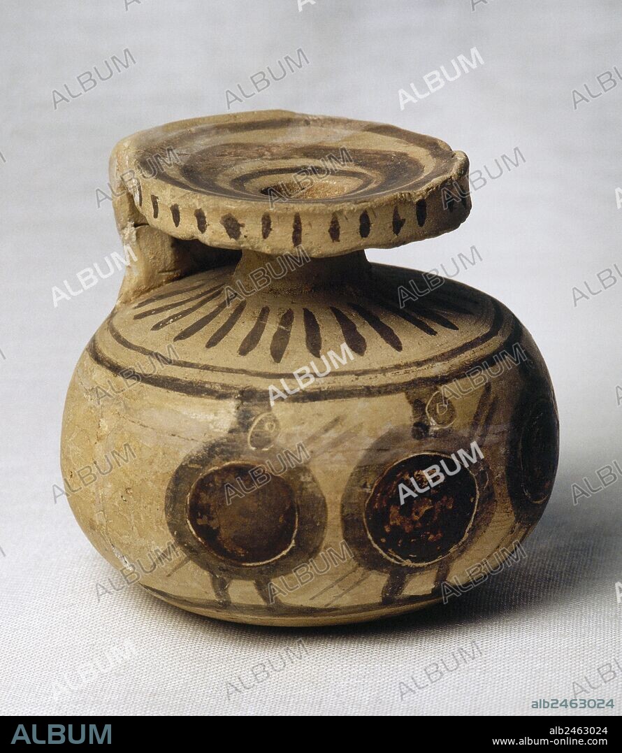 ARTE GRIEGO. SIGLO VI a. C. ARIBALO de tierra blanca-rojiza. Decorado con cuatro guerreros con escudos rojos y casco, cara y lanza de color marrón oscuro. Tiene 60 mm. de altura y 65 mm. de diámetro. Procede de Corinto (Grecia). Museo del Perfume. Barcelona. Cataluña.