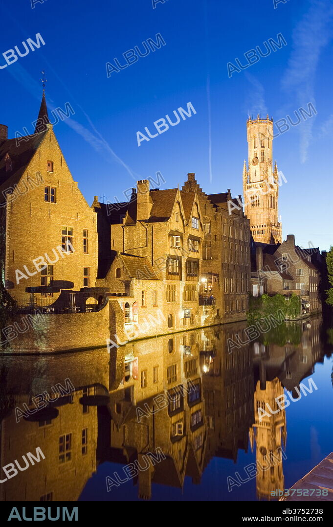 Reflection in canal of Belfort (belfry tower) illuminated at night, Old Town, UNESCO World Heritage Site, Bruges, Flanders, Belgium, Europe.