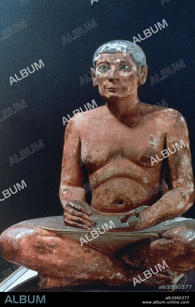 Ancient Egyptian figure of a seated scribe, 25th-24th century BC. The figure is of painted limestone with inlaid eyes of rock crystal. It dates from the 5th Dynasty. From the collection of the Louvre, Paris.