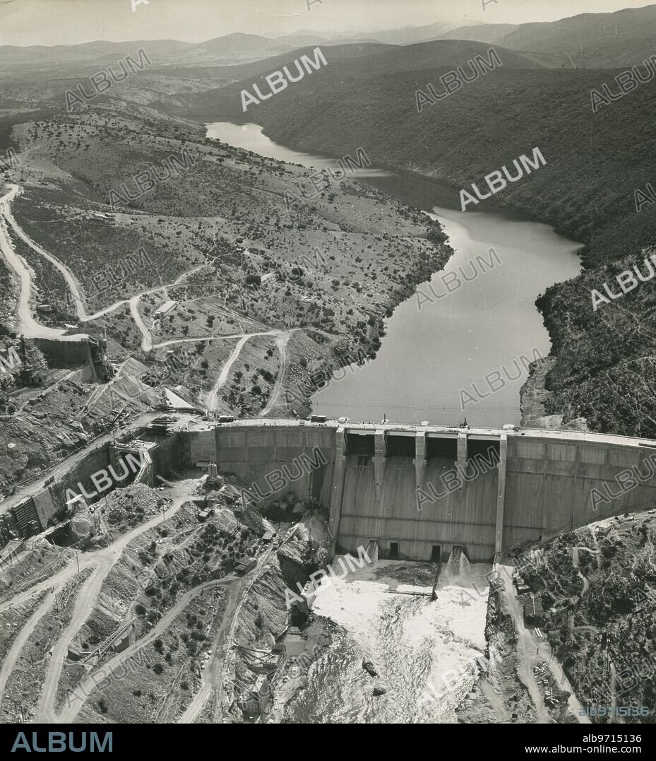 Torrejón el Rubio (Cáceres), octubre. Vista aérea de la presa de Torrejón el Rubio. A la izquierda puede apreciarse el trabajo de construcción del canal de trasvase de las aguas del Tajo al Tietar. Por rotura de una ataguia dicho túnel se inundó, atrapando en el interior a unos cincuenta obreros.
