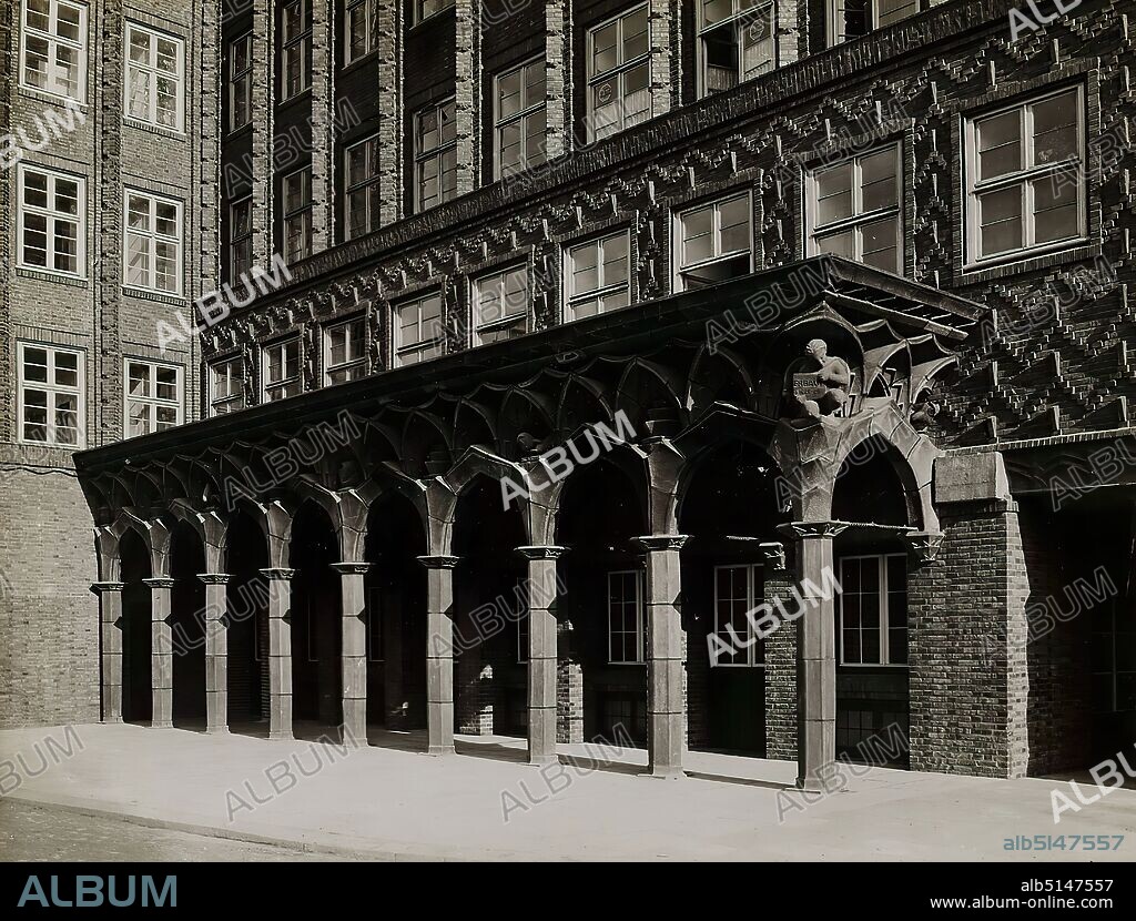 Photographenatelier Gebr. Dransfeld, Carl Dransfeld, Arcades on the north side of Chilehaus, Hamburg, silver gelatin paper, black and white positive process, image size: height: 17.30 cm; width: 22.70 cm, inscribed: recto on the cardboard: top right: Photo: Dransfeld, Hamburg 39; u.: Arcades on the north side of Chilehaus in Hamburg, Architect D. W.B. Fritz Höger Hamburg, Sculptor, Kuöhl Hamburg, architectural photography, arcade (architecture), sculpture, sculpture, sculpture art, The photo studio Gebr. Dransfeld was founded in 1902 by the trained lithographer Carl Dransfeld and his brother, the painter Adolf Dransfeld, in Berlin and moved to Hamburg in 1904. Building director Fritz Schumacher commissioned the Dransfeld brothers to document the public buildings he had constructed since 1909. This prestigious commission established the Dransfeld brothers as leading architectural photographers in 1920s Hamburg. Among the architects for whom the studio worked were Fritz Höger, Martin Elsaesser, Distel & Grubitz or the Gerson brothers. With their photograph of the Chile House designed by Höger, Carl and Adolf Dransfeld created an icon of architectural photography. By creating a strong view from below and using a wide-angle lens, they reinforced the expressionist character of the building's top, thus contributing significantly to the popularity of modern Hamburg brick architecture. (Sven Schumacher).