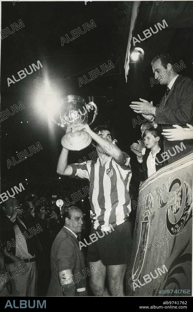 Madrid, 26/06/1976. Final de la Copa del Generalísimo, disputada en el estadio Santiago Bernabéu entre el Atlético de Madrid y el Real Zaragoza. En la imagen, el capitán del Atelti, Garate, recibe de manos del Rey Don Juan Carlos I el trofeo de campeón, acompañado de su hijo el Príncipe Felipe.