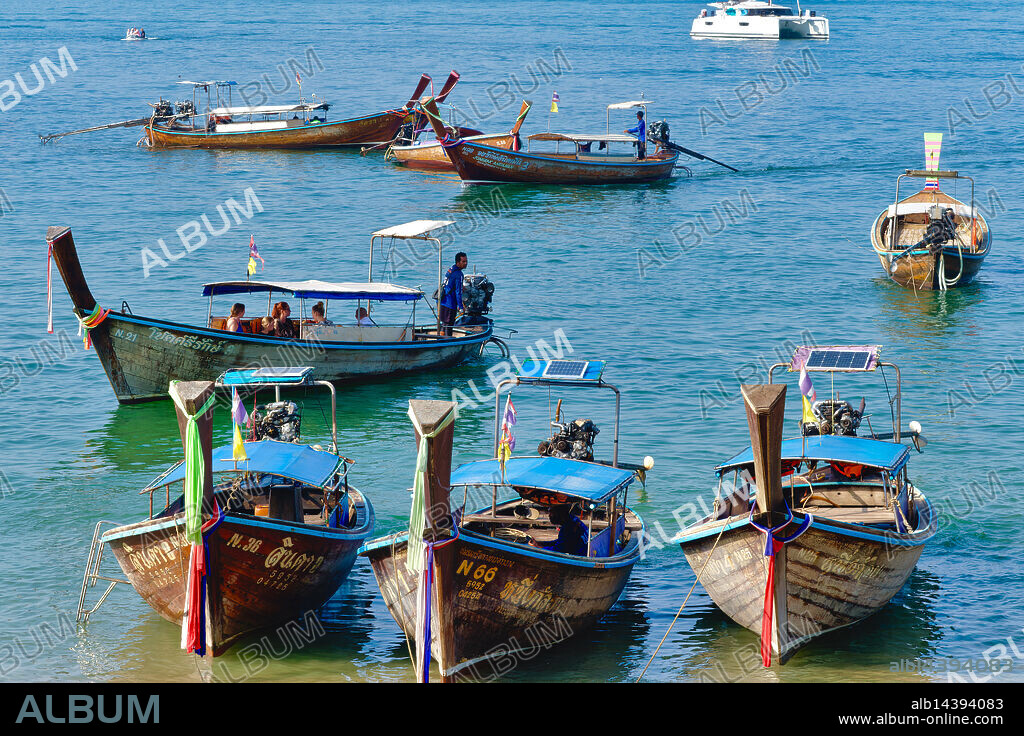 Thailand: Mostly longtail boats anchored off Ao Nang Beach, Krabi, ready to take tourists to outlying islands. Ao Nang, a beautiful bay and beach, is just west of the Phra Nang Peninsula, but separated from Ao Ton Sai by a rocky headland. Perhaps because it is easily accessible by road from Krabi, it's extremely popular and likely to be busy during peak season.