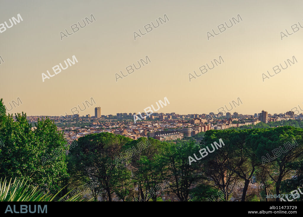Madrid skyline panoramic view with warm hues of the evening sky casting a golden glow on the buildings.