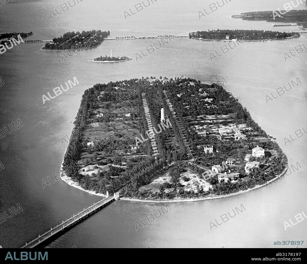 Miami Beach, Florida:  1932 An aerial view of Star Island, the artificial island estate built in Biscayne Bay by  Col. E. Green. In the background are the Venetian Islands, and at the extreme right is Miami Beach. The smaller island has a monument to Henry Flagler.   © Underwood Archives / The Image Works.