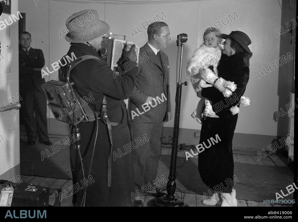 Göteborg 1935-12-17 - Fru Ossie Drimmer (e.likn) med barn troligen åker dessa med Gripsholm samma dag - vi har en fotograf och en man med mikrofon - kanske det är en filmkamera - . - *** Local Caption *** GT Låda 1935-december-01. KAMERAREPORTAGE.