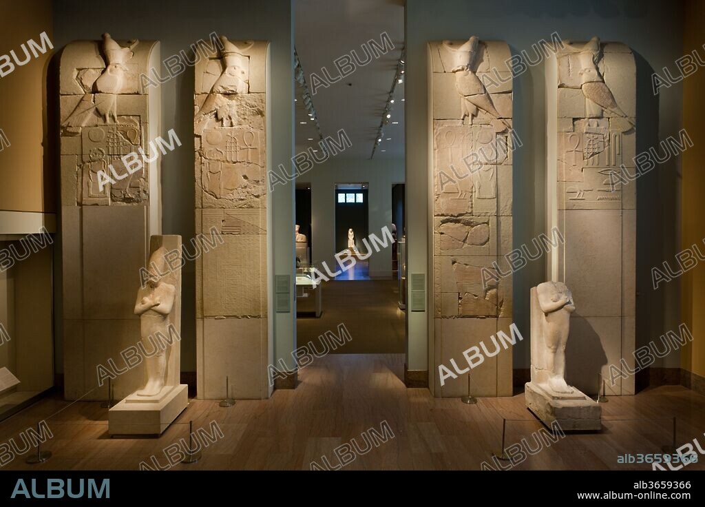 Name Panels from the Inner Wall of Senwosret I's Pyramid Complex. Dimensions: 34.1.205: 419.1 x 117.5 cm (165 x 46 1/4 in.)
34.1.206: 441.3 x 104.8 cm (173 3/4 x 41 1/4 in.)
34.1.207: 416.9 x 26.7 cm (164 1/8 x 10 1/2 in.)
34.1.208: 438.5 x 116.8 cm (172 5/8 x 46 in.). Dynasty: Dynasty 12. Reign: reign of Senwosret I. Date: ca. 1961-1917 B.C..
On both its inner and outer faces the stone enclosure wall around the pyramid of Senwosret I at Lisht was decorated with one hundred relief panels, four of which have been reconstructed here using excavated fragments. The panels represent an image of the world according to ancient Egyptian beliefs.  Between the fertile land below and the falcon of the sky above lies the realm of the pharaoh, symbolized by the ornate facade of his palace. Each rectangular field above the palace facade contains Senwosret's Horus name, "Living in births."  The two panels on the near side of the gallery door also proclaim his throne name, Kheperkare ("The evolution of Re's life force").  The king's birth name, Senwosret ("Man of the powerful [goddess]"), is added to his Horus name on the panel closest to the window.
To fit the available space in the gallery, the distance between the panels, once between 14 and 14 1/2 feet, has been much reduced, as has been the original height of 17 1/4 feet.