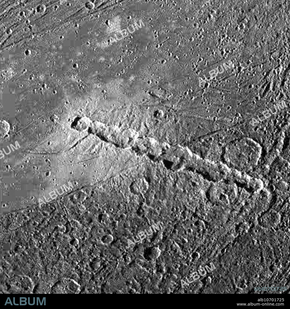 Enki Catena, a chain of 13 craters on Jupiter's moon, Ganymede. These craters were probably formed by a comet which was pulled into pieces by Jupiter's gravity as it passed too close to the planet. Soon after this breakup, the 13 fragments crashed onto Ganymede in rapid succession. The Enki craters formed across a sharp boundary between areas of bright terrain and dark terrain, delimited by a thin trough running diagonally across the centre of this image. North is to the bottom of the picture and the sun illuminates the surface from the left. The image was captured by NASA's Galileo spacecraft on April 5, 1997.